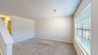 Located at 120 S Cranford Rd in Goose Creek, SC, this two-story home offers a practical and well-organized layout across two floors. The main level features a carpeted living room filled with natural light from a large front-facing window, with a staircase leading to the upper floor. The kitchen is outfitted with white cabinetry, gray laminate countertops, wood-look flooring, and a full suite of white appliances including a refrigerator, dishwasher, and electric range, illuminated by overhead track lighting. A dedicated laundry area with washer hookups and a water heater is also found on the main level, along with a bathroom featuring a vanity with a stone-look countertop. The upper level hosts two bedrooms, both carpeted and filled with natural light from multiple windows. The primary bedroom is generously sized and includes a ceiling fan, a door providing additional access, and ample wall space. The second bedroom features two windows overlooking greenery. A full bathroom on this floor includes a tub-shower combination and wood-look tile flooring. A hallway and closet complete the upper level, providing practical storage and circulation throughout the home.