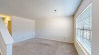 Located at 120 S Cranford Rd in Goose Creek, SC, this two-story home offers a practical and well-organized layout across two floors. The main level features a carpeted living room filled with natural light from a large front-facing window, with a staircase leading to the upper floor. The kitchen is outfitted with white cabinetry, gray laminate countertops, wood-look flooring, and a full suite of white appliances including a refrigerator, dishwasher, and electric range, illuminated by overhead track lighting. A dedicated laundry area with washer hookups and a water heater is also found on the main level, along with a bathroom featuring a vanity with a stone-look countertop. The upper level hosts two bedrooms, both carpeted and filled with natural light from multiple windows. The primary bedroom is generously sized and includes a ceiling fan, a door providing additional access, and ample wall space. The second bedroom features two windows overlooking greenery. A full bathroom on this floor includes a tub-shower combination and wood-look tile flooring. A hallway and closet complete the upper level, providing practical storage and circulation throughout the home.