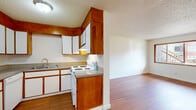 This single-story, one-bedroom, one-bathroom unit offers a practical and efficient layout across a modest footprint. The open-concept main area seamlessly integrates the living room, dining space, and kitchen, creating a unified and functional zone for everyday living. Warm wood-look flooring runs throughout the unit, providing a cohesive look, while textured ceilings add a classic residential character. The living room benefits from a large window that invites natural light and street views, keeping the space feeling bright and connected to the outside.

The kitchen is designed in a U-shaped configuration, featuring warm wood-toned cabinetry paired with white lower cabinet doors and white appliances, including a refrigerator, electric range, and dishwasher. A double-basin sink is positioned beneath upper cabinets, maximizing storage and workspace efficiency.

The bedroom offers a comfortable footprint with rich hardwood-toned flooring, a ceiling fan for climate comfort, and a full-width sliding closet with wood-panel doors. In addition to the bedroom closet, three closets throughout the unit provide generous storage capacity.

The bathroom includes a tub and shower combination, a toilet, and a single-sink vanity with white cabinetry, all finished with wood-look flooring that ties into the rest of the unit's design.