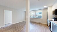 Located at 109 Jameson Ave in Toronto's vibrant Parkdale neighbourhood, this 2-bedroom, 1-bathroom unit offers a clean, modern aesthetic throughout. Light wood laminate flooring runs continuously across the entire space, creating a bright and cohesive feel. The open-concept kitchen and living area serves as the heart of the unit, featuring sleek white cabinetry extending to the ceiling, a grey subway tile backsplash, quartz countertops, stainless steel appliances, and a double undermount sink. A large window in the kitchen and living area fills the space with natural light and offers views of the surrounding neighbourhood. Both bedrooms are well-proportioned, each equipped with mirrored sliding closet doors that enhance the sense of space. The bedrooms benefit from oversized windows with views of mature trees, complemented by baseboard heating units. Neutral warm-grey walls throughout create a calm, versatile backdrop. The bathroom is finished with full white subway tile surrounding a deep soaker tub, providing a clean and timeless look. The overall ambiance of this unit is bright, modern, and move-in ready.
