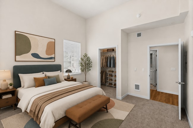 Staged bedroom showcasing the space and walk-in closet in the 841-square-foot one-bedroom Luxury floor plan. - 27 West Apartments