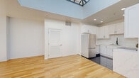 Located at 220 W 5th Street in the heart of downtown Los Angeles, this single-floor residence offers a thoughtfully designed layout with one bedroom, three bathrooms, a dedicated closet, and a connecting hallway. The open living and kitchen area is an immediate standout, boasting soaring ceilings, a skylight that floods the space with natural light, and warm light wood flooring that extends throughout. Large windows frame views of the downtown LA skyline, enhancing the bright and airy ambiance. The kitchen is well-appointed with crisp white shaker cabinetry, a stainless steel refrigerator, a marble-style countertop, and dark tile flooring that elegantly contrasts the surrounding hardwood. A sleek, dark-framed entry door adds a modern industrial touch to the living area. The spacious primary bedroom receives generous natural light through dual city-facing windows, offering views of the surrounding urban landscape. The bathrooms feature warm beige marble tile, with one showcasing a glass-enclosed combination tub and shower with a handheld fixture and white vanity cabinetry. Louvered interior doors add a classic architectural detail throughout. This residence balances modern minimalism with refined finishes in a prime downtown location.