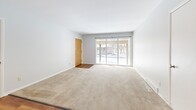 Located at 4493 S Buffalo St in Orchard Park, NY, this single-floor, 2-bedroom, 2-bathroom home offers a practical and comfortable layout. The open living area is a highlight, featuring rich hardwood flooring that extends toward the kitchen, while plush carpet covers the main lounge portion and all bedrooms. Large sliding glass doors in the living room invite ample natural light and provide outdoor access. The kitchen is well-appointed with white shaker-style cabinetry, marble-look countertops, a stylish black-and-white mosaic tile backsplash, stainless steel appliances including a refrigerator and dishwasher, and a window above the sink. A pass-through opening connects the kitchen to the living area, enhancing the open feel of the space. The primary bedroom is generously sized, carpeted, and includes a closet and dedicated hallway access. The second bedroom features a ceiling fan and a window with natural light. Two bathrooms serve the home, one of which includes a glass-enclosed walk-in shower with brushed nickel fixtures. A connecting hallway ties the layout together efficiently. The home's neutral gray-toned walls and clean white trim throughout create a bright, cohesive aesthetic suited to a variety of décor styles.