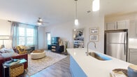 This well-appointed 2-bedroom, 2-bathroom residence in Cartersville, Georgia offers a comfortable and contemporary single-floor layout designed for modern living. The open-concept living, dining, and kitchen area creates a seamless flow, anchored by wood-look flooring, neutral walls, and abundant natural light. A ceiling fan in the living room adds both comfort and style, while large windows frame outdoor views.

The kitchen is a standout feature, boasting gray shaker-style cabinetry, white quartz countertops, a subway tile backsplash, and a full suite of stainless steel appliances including a refrigerator, range, microwave, and dishwasher. A peninsula with pendant lighting doubles as a breakfast bar and provides additional prep space.

The primary bedroom offers a private retreat with a walk-in closet, ceiling fan, and generous natural light. The second bedroom is equally comfortable, featuring large windows with views and ample closet storage. Both bedrooms are served by well-designed bathrooms — one with a tub/shower combination and the other with a vanity featuring gray cabinetry and a large mirror. The consistent wood-look flooring and clean, neutral palette tie the entire space together cohesively.