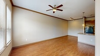 Located at 2500 S Millbend Dr in Spring, TX, this one-bedroom, one-bathroom single-floor residence offers a well-designed layout that maximizes every square foot. The living area features warm hardwood-style flooring, crown molding, and a ceiling fan, creating a bright and welcoming atmosphere. Large windows invite abundant natural light and provide views of the surrounding neighborhood. The open-concept kitchen and dining area is a standout feature, showcasing rich dark wood cabinetry with glass-front accents, a mosaic tile backsplash, black appliances, and a granite-topped island with a built-in sink and pendant lighting overhead. Track lighting adds a modern touch to the space. The spacious bedroom is finished with plush carpet, vaulted ceilings, and access to a walk-in closet, with an adjacent view into the kitchen. The full bathroom is elegantly appointed with a granite vanity, dark wood cabinetry, tile flooring, and an arched tub/shower surround with tile walls. Additional highlights include a dedicated laundry area with washer hookup, a pantry, multiple closets for storage, and a private patio. This residence offers a functional and stylish living experience in a convenient Spring, TX location.