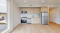 Located at 333 SE 120th Ave in Vancouver, Washington, this well-appointed 2-bedroom, 2-bathroom residence offers a clean, modern aesthetic across a single floor. The layout is efficiently organized, connecting all rooms through a central hallway.

The kitchen is a standout feature, outfitted with light wood cabinetry, stainless steel appliances including a range, microwave, dishwasher, and refrigerator, and light-toned countertops. Light hardwood-style flooring runs throughout the kitchen, adding warmth, while a large window provides an abundance of natural light and outdoor views.

Both bedrooms feature soft, neutral carpeting and crisp white walls. Each room is equipped with a wall-mounted mini-split unit for individual climate control, as well as sliding closet doors offering generous storage. The primary bedroom includes a window with outdoor views of surrounding greenery.

The two bathrooms are finished with light hardwood-style flooring and white walls. One bathroom features a combination tub and shower with chrome fixtures, while the other includes a vanity with warm wood cabinetry and a toilet. Both maintain a clean, minimalist design.

Throughout the residence, the consistent use of light tones, modern fixtures, and natural light creates a bright, comfortable, and cohesive living environment.