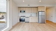 Located at 333 SE 120th Ave in Vancouver, Washington, this well-appointed 2-bedroom, 2-bathroom residence offers a clean, modern aesthetic across a single floor. The layout is efficiently organized, connecting all rooms through a central hallway.

The kitchen is a standout feature, outfitted with light wood cabinetry, stainless steel appliances including a range, microwave, dishwasher, and refrigerator, and light-toned countertops. Light hardwood-style flooring runs throughout the kitchen, adding warmth, while a large window provides an abundance of natural light and outdoor views.

Both bedrooms feature soft, neutral carpeting and crisp white walls. Each room is equipped with a wall-mounted mini-split unit for individual climate control, as well as sliding closet doors offering generous storage. The primary bedroom includes a window with outdoor views of surrounding greenery.

The two bathrooms are finished with light hardwood-style flooring and white walls. One bathroom features a combination tub and shower with chrome fixtures, while the other includes a vanity with warm wood cabinetry and a toilet. Both maintain a clean, minimalist design.

Throughout the residence, the consistent use of light tones, modern fixtures, and natural light creates a bright, comfortable, and cohesive living environment.