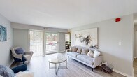 Located at 70 Greenway Sq in Dover, Delaware, this well-appointed two-bedroom, two-bathroom residence offers a thoughtfully designed single-level layout. Light wood-style flooring runs throughout, creating a cohesive and clean aesthetic across all rooms.

The spacious living room serves as the heart of the home, bathed in natural light from large sliding glass doors that open directly onto a private balcony with outdoor views. The open sightline connects seamlessly to the combined dining room and kitchen, making the space feel open and functional.

The kitchen is equipped with stainless steel appliances, including a range, dishwasher, and refrigerator, complemented by white raised-panel cabinetry and stone-look countertops. Track lighting illuminates the workspace efficiently.

A well-proportioned hallway, accented with decorative wall mirrors, connects the living areas to the private quarters. The generously sized primary bedroom includes its own en-suite bathroom and closet, while the second bedroom also offers a closet and convenient access to the second full bathroom. Both bathrooms feature wood-style flooring and clean, bright finishes.

Additional highlights include four closets for ample storage, a dedicated utility room, and a layout that balances privacy with open living. The overall ambiance is bright, modern, and move-in ready.