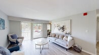 Located at 70 Greenway Sq in Dover, Delaware, this well-appointed two-bedroom, two-bathroom residence offers a thoughtfully designed single-level layout. Light wood-style flooring runs throughout, creating a cohesive and clean aesthetic across all rooms.

The spacious living room serves as the heart of the home, bathed in natural light from large sliding glass doors that open directly onto a private balcony with outdoor views. The open sightline connects seamlessly to the combined dining room and kitchen, making the space feel open and functional.

The kitchen is equipped with stainless steel appliances, including a range, dishwasher, and refrigerator, complemented by white raised-panel cabinetry and stone-look countertops. Track lighting illuminates the workspace efficiently.

A well-proportioned hallway, accented with decorative wall mirrors, connects the living areas to the private quarters. The generously sized primary bedroom includes its own en-suite bathroom and closet, while the second bedroom also offers a closet and convenient access to the second full bathroom. Both bathrooms feature wood-style flooring and clean, bright finishes.

Additional highlights include four closets for ample storage, a dedicated utility room, and a layout that balances privacy with open living. The overall ambiance is bright, modern, and move-in ready.