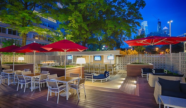 Meet up with friends at the Skyline Lounge with outdoor TV's, bar area, and fire pit - Park Towne Place Apartments