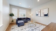 This well-designed three-story home offers four bedrooms, two bathrooms, and a thoughtful layout spread across three distinct floors. The entry level provides a compact yet functional footprint, while the main living floor opens up to a bright, combined kitchen and living area. The kitchen is outfitted with white shaker-style cabinetry, stainless steel appliances including a refrigerator, range, microwave, and dishwasher, and light wood-look flooring that extends into the living space. The living room features recessed lighting, large windows with horizontal blinds that invite abundant natural light, and a clean, open atmosphere. The upper floors house the four bedrooms, including a spacious primary bedroom with wide windows, plush carpeting, and ample room for furnishings. The additional bedrooms are similarly carpeted and bright, offering versatile use. Two hallways and three staircases connect the floors efficiently. Both bathrooms are finished with light wood-look flooring, white cabinetry, and glass-enclosed showers. Throughout the home, a neutral color palette of soft whites and warm beiges creates a cohesive, modern aesthetic that is both inviting and functional.