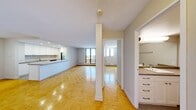 This well-appointed one-bedroom, one-bathroom unit offers a thoughtfully designed layout that maximizes every inch of its compact footprint. The open-concept living and kitchen area serves as the heart of the home, featuring warm parquet wood flooring that extends throughout, a textured ceiling, and an abundance of natural light streaming in through large windows and a sliding glass door. The kitchen is outfitted with crisp white cabinetry, a stainless steel refrigerator, a stove, and a peninsula counter that provides additional workspace and separates the cooking area from the living space. The sliding glass door opens to a private balcony, offering panoramic views of the surrounding landscape under open skies — a standout feature of this elevated unit. The bedroom is a comfortable, well-lit retreat with its own window, parquet flooring, a double closet, and direct access to the hallway. The bathroom is clean and functional, featuring a full-size soaking tub with tiled surround, a toilet, and a vanity with storage drawers. Neutral tones, baseboard heating throughout, and a practical layout make this a versatile and move-in ready space.