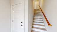 Located at 140 Hillside Cottage Lane in Nashville, TN, this three-bedroom, five-bathroom home spans three floors with a thoughtful layout designed for comfortable living. The entry level provides a welcoming introduction to the home, featuring light wood-tone flooring and crisp white walls that carry consistently throughout all levels. A staircase with light wood treads, white risers, and a warm wood handrail connects each floor with clean, modern detailing.

The main living floor serves as the heart of the home, highlighted by a well-appointed kitchen featuring white shaker-style upper cabinetry, gray lower cabinets, stainless steel appliances, a herringbone tile backsplash, and a large center island with a white countertop and built-in sink — ideal for both cooking and entertaining. Light pours in through windows, enhancing the open, airy feel.

Each bedroom is generously proportioned with light hardwood flooring and ceiling fans. The primary bedroom includes access to a dedicated closet with built-in shelving. The five bathrooms are finished with neutral tile flooring, gray shaker vanities, white countertops, framed mirrors, and clean white tub-shower surrounds with integrated shelving. Two closets and two hallways further enhance storage and circulation throughout this well-designed Nashville home.
