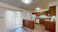 This updated two-story home in Memphis, Tennessee offers a well-designed layout across two floors. The main level features a bright, open living area with light wood-style flooring and a carpeted staircase with black metal railing leading to the upper level. Natural light flows in through windows near the front entry, creating a welcoming atmosphere. The kitchen is a functional highlight, equipped with warm-toned wood cabinetry, granite-style countertops, a peninsula with additional storage, and white appliances including a refrigerator, dishwasher, and electric range. A sliding glass door off the kitchen opens to a view of lush greenery, adding a pleasant outdoor connection. A convenient half bath on the main level features a wood-cabinet vanity with stone-style countertop and hardwood-style flooring. Upstairs, two carpeted bedrooms provide comfortable retreats, each with windows that allow natural light. The full bathroom on the upper level includes tile wall surround, a shower/tub combination, and a marble-style vanity countertop. Throughout the home, textured ceilings and neutral wall tones create a clean, move-in-ready environment suitable for comfortable everyday living.
