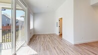 Located at 7625 19th Ln SE in Lacey, WA, this thoughtfully designed unit offers a clean, modern aesthetic across its single floor. Light wood-tone luxury vinyl plank flooring runs throughout, complementing the crisp white walls and bright, airy atmosphere created by recessed lighting and large windows.

The open-concept kitchen and living area serves as the heart of the space. The kitchen features two-tone cabinetry — warm wood uppers paired with slate-gray lower cabinets — stainless steel appliances including a gas range, microwave, and refrigerator, and light countertops that tie the palette together. A sliding glass door in the living area opens onto a private balcony, inviting natural light and neighborhood views indoors.

Two full bathrooms provide functional comfort, each finished with the same light flooring and clean white walls. A hallway area accommodates in-unit washer and dryer hookups, adding everyday convenience. Two closets and a dedicated pantry offer ample storage throughout the unit.

An accent wall in a muted slate blue adds a subtle touch of character to the living space, while large windows in the bedroom area allow natural light to pour in. The overall design is cohesive and contemporary, making efficient use of every corner of this compact yet complete Lacey residence.