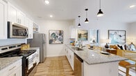 Located at 415 Curtis Pkwy SE in Calhoun, Georgia, this single-story 2-bedroom, 2-bathroom residence offers a thoughtfully designed layout with modern finishes throughout. Light wood-tone flooring flows seamlessly across the home, complemented by crisp white walls and recessed lighting that create a clean, bright atmosphere.

The kitchen is a standout feature, showcasing white shaker cabinetry, granite countertops, a peninsula with bar seating, stainless steel appliances — including a refrigerator, range, microwave, and dishwasher — and sleek pendant lighting overhead. The kitchen opens naturally toward the living area, reinforcing the home's open-concept feel.

A well-proportioned hallway connects the living spaces to the bedrooms, with two closets providing ample storage. The spacious primary bedroom offers a comfortable retreat with its own en-suite bathroom, which features a glass-enclosed walk-in shower, white vanity cabinetry, and granite countertops. The second bedroom benefits from generous natural light through large windows with blinds and a ceiling fan. The second bathroom includes a full soaking tub and shower combination. Throughout the home, consistent finishes and a neutral palette provide a cohesive, move-in-ready living environment.