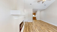 Located at 708 South Parrish Avenue in Adel, Georgia, this single-story 2-bedroom, 2-bathroom home offers a thoughtfully designed layout that maximizes functionality and comfort. The open-concept living, dining, and kitchen area serves as the heart of the home, anchored by a striking linear fireplace with a white-trimmed surround and vaulted ceiling detail. A ceiling fan overhead and a bright front window fill the space with natural light, while wood-look luxury vinyl flooring runs seamlessly throughout. The kitchen is well-equipped with light wood shaker-style cabinetry, white countertops, stainless steel appliances including a refrigerator, range, microwave, and dishwasher, plus a double basin sink. A pantry adds convenient storage. Both bedrooms feature ceiling fans, natural light from windows with blinds, and continue the cohesive wood-look flooring. The primary bedroom includes an en-suite bathroom and direct access to a closet. Both bathrooms are finished with marble-look tile flooring, tub-shower combinations, and warm wood vanities. Additional spaces include a laundry room, utility room, hallway, and two closets, rounding out a practical and move-in ready home.