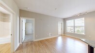 Located at 5616 Infinity Ln in Virginia Beach, VA, this two-bedroom, one-bathroom residence offers a practical and well-designed single-floor layout. The open living area is finished with light wood-style flooring and neutral gray walls, creating a bright and clean aesthetic throughout.

The kitchen is a standout feature, boasting rich dark wood cabinetry, stainless steel appliances including a refrigerator, range, microwave, and dishwasher, and a mosaic tile backsplash that adds a modern touch. The kitchen flows seamlessly into the living area, making it well-suited for everyday living.

The primary bedroom offers a comfortable footprint with carpeted flooring and connects to a walk-in closet equipped with wire shelving and hanging rods for organized storage. The second bedroom also features carpet, a ceiling fan, and a window with outdoor views of the surrounding area. The full bathroom includes a tub-shower combination with chrome fixtures and light wood-style flooring. Additional practical features include an accessible utility panel and built-in HVAC venting. The space is bathed in natural light from well-placed windows throughout.