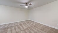 Located at 316 Columbia Dr in Carrollton, GA, this apartment offers a well-organized single-floor layout with three bedrooms, three bathrooms, a combined kitchen and living area, and a dedicated utility room. The kitchen is outfitted with light wood cabinetry, dark countertops, stainless steel appliances including a refrigerator, electric range, over-the-range microwave, and dishwasher, all set atop wood-look flooring. Open shelving provides additional pantry storage. The living area flows naturally from the kitchen and features the same durable hard-surface flooring. Each of the three carpeted bedrooms is finished with neutral beige tones, white trim, and window blinds that allow natural light while maintaining privacy. The primary bedroom includes a ceiling fan with light fixture. The bathrooms are clean and functional, each featuring a soaking tub with shower combination, white surrounds, and chrome fixtures. One bathroom features a white vanity with ample drawer storage. Throughout the unit, a consistent neutral color palette and clean finishes create a bright, cohesive atmosphere. The utility room adds practical convenience to this thoughtfully designed residential space.
