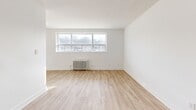 Located at 205-207 Morningside Ave in Toronto's Morningside neighbourhood, this well-appointed 4-bedroom, 1-bathroom unit offers a thoughtfully designed single-floor layout with a clean, modern aesthetic throughout. Light wood-look flooring runs seamlessly across the entire space, complementing the crisp white walls and creating a bright, cohesive feel.

The kitchen features white shaker-style cabinetry, stainless steel appliances including a refrigerator and stove, and a window that invites natural light. It connects fluidly to the adjacent living area, making the space feel open and practical.

Each of the four bedrooms is well-proportioned, with large windows framing outdoor views and classic cast-iron radiators providing warmth. The primary bedroom includes a built-in sliding-door closet for ample storage. Additional bedrooms offer similar natural light and a calm, neutral palette suitable for a variety of uses.

The bathroom is finished with white subway tile surrounds, a soaking tub with overhead shower, chrome fixtures, and a vanity with sink — combining classic style with everyday functionality.

Multiple hallways connect the rooms efficiently, and a dedicated closet adds further storage. The overall ambiance is clean, bright, and move-in ready, making this a practical and comfortable unit for shared or family living.