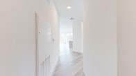 Located in Flemington, NJ, this thoughtfully designed 3-bedroom, 2-bathroom residence offers a clean, contemporary aesthetic throughout its single floor of living space. Light-toned hardwood flooring runs continuously through the home, complementing the crisp white walls and recessed lighting that create a bright, airy ambiance.

The open-concept kitchen and living area serves as the heart of the home. The kitchen is appointed with warm wood cabinetry extending to the ceiling, stainless steel appliances including a gas range, microwave, dishwasher, and refrigerator, as well as a white subway tile backsplash and a generous center island with a quartz countertop — ideal for both cooking and entertaining. Expansive floor-to-ceiling windows flood the living area with natural light and provide open views of the surrounding landscape.

The primary bedroom is a comfortable retreat, featuring large sliding glass doors that open to a private balcony with scenic outdoor views. Two additional bedrooms offer versatile space, each with access to a dedicated closet with built-in shelving. The bathrooms are finished in a modern style, with large-format tile flooring, wood-toned vanities, white quartz countertops, and framed mirrors. A dedicated closet provides additional storage throughout the unit.
