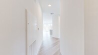 Located in Flemington, NJ, this thoughtfully designed 3-bedroom, 2-bathroom residence offers a clean, contemporary aesthetic throughout its single floor of living space. Light-toned hardwood flooring runs continuously through the home, complementing the crisp white walls and recessed lighting that create a bright, airy ambiance.

The open-concept kitchen and living area serves as the heart of the home. The kitchen is appointed with warm wood cabinetry extending to the ceiling, stainless steel appliances including a gas range, microwave, dishwasher, and refrigerator, as well as a white subway tile backsplash and a generous center island with a quartz countertop — ideal for both cooking and entertaining. Expansive floor-to-ceiling windows flood the living area with natural light and provide open views of the surrounding landscape.

The primary bedroom is a comfortable retreat, featuring large sliding glass doors that open to a private balcony with scenic outdoor views. Two additional bedrooms offer versatile space, each with access to a dedicated closet with built-in shelving. The bathrooms are finished in a modern style, with large-format tile flooring, wood-toned vanities, white quartz countertops, and framed mirrors. A dedicated closet provides additional storage throughout the unit.