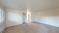 Located at 1285 Montecito Ave in Mountain View, California, this single-floor residence offers a clean, well-maintained interior with a straightforward and functional layout. The entryway greets visitors with a distinctive red six-panel front door, flanked by windows that allow natural light to filter in, offering views of the surrounding greenery. The living area flows naturally from the entry and features wood-look flooring, a ceiling fan, and baseboard heating.

The galley-style kitchen is efficiently designed with white shaker cabinetry extending floor to ceiling on both sides, gray quartz countertops, a stainless steel refrigerator and range, and wood-look flooring that ties the space together cohesively.

The bedrooms are carpeted and feature white panel doors and generous closet space. One bedroom includes a built-in shelved walk-in closet, while another offers a mirrored sliding-door closet with a window overlooking the outdoors. A third spacious bedroom provides a panel-door closet with shelving alongside an additional door for convenient access.

The bathroom is appointed with a tub and shower combination enclosed by sliding frosted-glass doors, set against marble-patterned wall surrounds with chrome accents. Throughout the residence, the neutral white walls and clean finishes create a bright, versatile atmosphere ready for personalization.