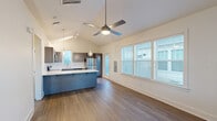 Located at 66 Aldrin Dr NW in Huntsville, Alabama, this well-designed 1-bedroom, 2-bathroom home offers a smart, efficient layout across a single floor. The open-concept living and kitchen area is immediately inviting, highlighted by striking vaulted ceilings and a ceiling fan that enhances the sense of volume and airflow. Wide-plank hardwood-style flooring runs throughout, lending warmth and continuity to the space.

The kitchen is a standout feature, showcasing gray shaker cabinetry, a herringbone tile backsplash, bright white countertops, and a full suite of stainless steel appliances including a refrigerator, range, microwave, and dishwasher. A peninsula with a bold blue base and pendant lighting above serves as both a functional workspace and a visual anchor for the open living area. Multiple windows along the living room walls flood the space with natural light while offering neighborhood views.

The bedroom is a quiet, comfortable retreat with hardwood-style flooring, a ceiling fan, and windows on two walls providing ample natural light. The two bathrooms are clean and modern, with one featuring a glass-enclosed walk-in shower and a vanity with a framed mirror. A hallway and closet round out the practical layout, ensuring efficient use of every square foot in this thoughtfully designed home.