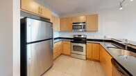 Located on the 10th floor at 10 Commerce Ave SW in downtown Grand Rapids, Michigan, this 2-bedroom, 2-bathroom unit offers a well-designed, modern living space. The open-concept layout connects the kitchen and living area seamlessly, with hardwood-style flooring running throughout the main living spaces and tile in the kitchen and bathrooms.

The kitchen is equipped with stainless steel appliances—including a refrigerator, electric range, built-in microwave, and dishwasher—complemented by warm maple cabinetry, dark granite countertops, and a peninsula with additional prep and storage space. Track lighting illuminates the kitchen and flows into the living area.

The living room features large windows that flood the space with natural light and offer elevated views of the surrounding Grand Rapids cityscape. Both bedrooms continue the hardwood-style flooring, with the primary bedroom offering generous proportions and walk-in closet access. Additional windows in the bedrooms further enhance the sense of openness and provide added city views.

The two bathrooms are finished consistently with tile flooring, maple vanities, dark granite countertops, and stainless steel fixtures. The primary bathroom includes a glass-enclosed shower and an extended vanity with ample storage. The overall aesthetic is clean, contemporary, and functional throughout.