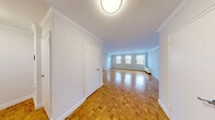 Located at 41 Elm Street, Unit 2C in Morristown, NJ, this two-bedroom, two-bathroom residence offers a thoughtfully designed single-floor layout. Warm parquet wood flooring flows throughout the living spaces, adding classic character to each room.

The spacious living room is a standout feature, benefiting from multiple windows that invite generous natural light and views of the surrounding neighborhood. Crown molding accents the walls, lending a refined, polished feel to the open space.

The kitchen is clean and functional, featuring white shaker-style cabinetry, white quartz countertops, a subway tile backsplash, white tile flooring, and stainless steel appliances including a range, microwave, and dishwasher. A window above the sink provides natural light.

The primary bedroom is generously sized, also featuring parquet flooring and a window with outdoor views. The second bedroom similarly benefits from the consistent design language found throughout the unit.

Both bathrooms are well-appointed with large-format white tile. One includes a glass-enclosed walk-in shower with a white vanity, while the second features a full soaking tub with shower combo and matching vanity.