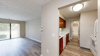 Located at 6870 E Livingstone Ave in Reynoldsburg, Ohio, this single-floor, 3-bedroom, 1-bathroom home offers a practical and well-organized layout. Wood-look laminate flooring runs consistently throughout the space, lending a cohesive and clean aesthetic to every room.

The entrance opens into a central hallway that connects the main living areas and bedrooms. The living area is bright and open, highlighted by a sliding glass door that provides direct access to an outdoor balcony and fills the room with natural light and greenery views.

The kitchen features warm-toned medium wood cabinetry — both upper and lower — paired with white countertops and a white dishwasher, creating a clean contrast. It opens conveniently toward the main living space, enhancing functionality.

All three bedrooms are carpeted with neutral-toned walls and feature louvered bi-fold closet doors with built-in hanging rods and shelving. The spacious primary bedroom offers ample room for furnishing. The secondary bedrooms are cozy and well-proportioned with their own closets.

The full bathroom includes a tub-shower combination with tiled surround, a white vanity, and light flooring, maintaining the home's clean, neutral palette. Textured ceilings are present throughout, adding a classic residential touch. The hallway provides seamless access to all rooms, keeping the floor plan efficient and easy to navigate.