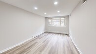 Located in Chicago's vibrant Lakeview neighborhood, this thoughtfully designed one-bedroom, one-bathroom unit at 3161 N Cambridge Ave offers a clean, modern aesthetic throughout its efficiently utilized single-floor layout. Light wood-style luxury vinyl plank flooring runs continuously through every room, creating a cohesive and warm feel across the entire space.

The open living area is brightened by a trio of windows that draw in natural light, complemented by recessed ceiling lighting for a polished, well-lit atmosphere. Neutral gray walls and crisp white baseboards give the space a fresh, move-in-ready appearance. A ceiling fan adds functional comfort to the main living zone, which flows naturally into the bedroom corridor.

The bedroom is a well-proportioned private retreat, featuring its own window with views of surrounding greenery, recessed lighting, and a double-door closet offering ample storage. The room's neutral palette and clean finishes make it versatile and inviting.

The bathroom is finished with bright white subway tile surrounding a full soaking tub and shower combination, accented by chrome fixtures for a timeless, clean look.

The 3D dollhouse view reveals a thoughtfully arranged floor plan with a kitchen area, well-defined living and sleeping spaces, and efficient circulation throughout — making the most of every square foot this unit has to offer.