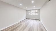 Located in Chicago's vibrant Lakeview neighborhood, this thoughtfully designed one-bedroom, one-bathroom unit at 3161 N Cambridge Ave offers a clean, modern aesthetic throughout its efficiently utilized single-floor layout. Light wood-style luxury vinyl plank flooring runs continuously through every room, creating a cohesive and warm feel across the entire space.

The open living area is brightened by a trio of windows that draw in natural light, complemented by recessed ceiling lighting for a polished, well-lit atmosphere. Neutral gray walls and crisp white baseboards give the space a fresh, move-in-ready appearance. A ceiling fan adds functional comfort to the main living zone, which flows naturally into the bedroom corridor.

The bedroom is a well-proportioned private retreat, featuring its own window with views of surrounding greenery, recessed lighting, and a double-door closet offering ample storage. The room's neutral palette and clean finishes make it versatile and inviting.

The bathroom is finished with bright white subway tile surrounding a full soaking tub and shower combination, accented by chrome fixtures for a timeless, clean look.

The 3D dollhouse view reveals a thoughtfully arranged floor plan with a kitchen area, well-defined living and sleeping spaces, and efficient circulation throughout — making the most of every square foot this unit has to offer.