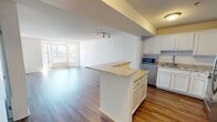 This contemporary 700 square foot apartment in Minneapolis offers a thoughtfully designed living space. The heart of the home is the open-concept kitchen and living area, showcasing a blend of functionality and style. The kitchen boasts white cabinetry, stainless steel appliances, and elegant granite countertops, creating a sleek culinary space. A generously sized kitchen island doubles as a breakfast bar, perfect for casual dining or entertaining.

The living room features warm wood-look flooring and is bathed in natural light from large windows, which also provide stunning city views. A standout feature is the bay window area, offering a cozy nook for relaxation or a home office setup.

The bedroom, measuring 180 square feet, provides ample space and includes a spacious closet with sliding doors. Plush carpeting adds comfort underfoot. The bathroom continues the modern aesthetic with clean lines and a combination tub/shower.

Throughout the apartment, recessed lighting and track lighting fixtures enhance the contemporary feel. The neutral color palette creates a bright, airy atmosphere that can easily be personalized. This well-laid-out apartment maximizes every inch of its 700 square feet, offering a perfect blend of style and practicality for urban living.