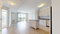 Located at 301 Commons Park S in Stamford, Connecticut, this well-appointed one-bedroom, one-bathroom residence offers a thoughtfully designed open-concept layout filled with natural light and modern finishes throughout. Light-toned hardwood-style flooring flows seamlessly through the main living areas, creating a bright and cohesive aesthetic.

The kitchen is a standout feature, showcasing light wood cabinetry with sleek hardware, granite countertops, a classic white subway tile backsplash, and a full suite of stainless steel appliances including a gas range, built-in microwave, dishwasher, and refrigerator. A central kitchen island provides additional prep space and casual seating. A stacked in-unit washer and dryer is conveniently accessible nearby.

The open living area flows effortlessly toward a sliding glass door that leads to a private balcony, where elevated views reveal a resort-style pool, lush greenery, and the surrounding Stamford skyline — ideal for relaxing or entertaining outdoors.

The bedroom features plush carpeting and large windows that allow ample natural light to fill the room. The bathroom is finished with warm tile flooring, light wood vanity cabinetry, a white countertop, and a large mirror. The overall ambiance of the residence is clean, contemporary, and move-in ready.