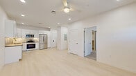 This single-story unit offers a thoughtfully designed layout that maximizes its compact footprint. The interior is finished with a crisp, all-white palette and light-toned luxury vinyl plank flooring in the main living areas, creating a bright and cohesive aesthetic throughout.

The kitchen is a standout feature, equipped with full-height white shaker cabinetry, under-cabinet lighting, a subway tile backsplash, and dark countertops that provide a refined contrast. A complete suite of stainless steel appliances — including a refrigerator, range, microwave, and dishwasher — makes it fully functional and move-in ready.

The bedroom is carpeted for comfort and benefits from natural light through multiple windows with exterior views. A dedicated closet with built-in shelving offers practical storage. The adjoining bathroom features a soaking tub and shower combination with chevron-patterned tile surround and brushed gold fixtures, adding a polished, contemporary detail.

Recessed lighting throughout ensures consistent illumination, while a ceiling fan in the main living area adds comfort. The overall ambiance is clean, modern, and efficiently organized, making excellent use of the available space.