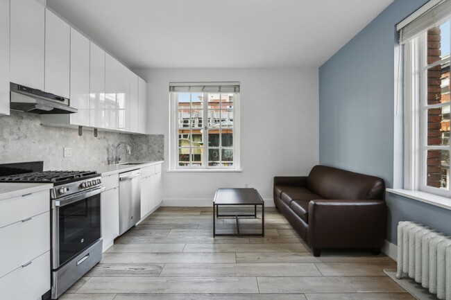 Kitchen with multiple cabinets, refrigerator, stove, range hood, and sink - 2500 Durant Avenue