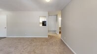 Located at 3600 Park Lake Ln in Peachtree Corners, GA, this single-story, one-bedroom, one-bathroom home offers a practical and comfortable layout across a well-utilized floor plan. The living area is a standout feature, anchored by a classic wood-burning fireplace framed by a white mantel and flanked by two windows that allow natural light to fill the carpeted space. A secondary living area flows openly from the main room, providing added flexibility for dining or a home office setup. Neutral-toned walls and plush carpeting throughout lend a clean, cohesive aesthetic. The kitchen is equipped with white cabinetry, light granite-style countertops, a black electric range with overhead ventilation, and durable wood-look flooring. The bedroom is a comfortable size, featuring carpet flooring, a large window with outdoor views, and direct access to a closet. The bathroom includes a granite-top vanity with a white undermount sink, a medicine cabinet mirror, and a full tub-shower combo with built-in shelving. A dedicated laundry area houses a full-size washer and dryer. Three closets and a utility room provide ample storage throughout the home.