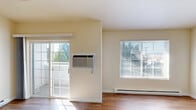 Located in Spokane Valley, WA, this 2-bedroom, 1-bathroom unit offers a well-organized single-level layout with a warm, neutral palette and hardwood-style flooring throughout. The combined dining and living area is bright and airy, featuring multiple windows that invite abundant natural light, a sliding glass door that opens to a private balcony, and a baseboard heating system. The balcony overlooks a lush, tree-lined neighborhood with scenic mountain views in the distance. The kitchen is efficiently designed with warm wood cabinetry, granite-style countertops on both sides, and light flooring, providing ample storage and prep space. A hallway connects the main living area to the two bedrooms and the shared bathroom. The primary bedroom is generously sized, featuring tall ceilings that enhance the sense of openness, a large window for natural light, and baseboard heating. The second bedroom is cozy and well-lit with its own window overlooking the greenery outside. The full bathroom includes a tub/shower combo, a vanity with wood cabinetry, and hardwood-style flooring, maintaining the cohesive aesthetic found throughout the unit.