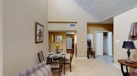 Located at 15035 Westpark Dr in Houston, Texas, this single-story residence offers a well-designed layout with a warm, neutral color palette throughout. The living room is a standout space, boasting dramatically vaulted ceilings, a ceiling fan, a tiled fireplace, and large windows that invite natural light. Plush carpeting and an open flow into the dining area make this an inviting gathering space. The dining area connects seamlessly to the kitchen, which features a galley-style layout with rich wood cabinetry, tile backsplash, laminate countertops, hardwood-style flooring, and a full suite of appliances. Two bedrooms provide comfortable retreats, each with vaulted ceilings, carpeted floors, and windows with blinds. The primary bedroom includes a private door leading to an outdoor space. Two bathrooms are present, each equipped with a tub-shower combination and wood cabinetry. Additional highlights include a tiled entryway, closet storage, and a cohesive design that balances functionality with a comfortable residential ambiance throughout the single-floor plan.