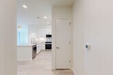 Located at 46 Soldiers Field Pl in Boston, MA, this thoughtfully designed residence offers three bedrooms, two bathrooms, and a single-floor layout that maximizes functionality and comfort. Light-toned luxury vinyl plank flooring flows throughout the entire unit, creating a cohesive and airy atmosphere.

The modern kitchen is a standout feature, showcasing white shaker cabinetry extending to the ceiling, a quartz waterfall island with an undermount sink, stainless steel appliances including a built-in microwave, electric range, and refrigerator, all illuminated by pendant lighting and recessed ceiling fixtures. The open layout connects seamlessly to the living area.

The primary bedroom is generously proportioned and benefits from large sliding glass doors that open to a private balcony with views of the surrounding Boston neighborhood. Additional bedrooms are bright and well-sized, each featuring large windows with urban and greenery views and ample closet space. Four closets total provide excellent storage throughout the unit.

The bathroom features subway tile in the walk-in shower with a glass door enclosure, large-format floor tiles, a floating white vanity, and a polished chrome fixture. An in-unit laundry area adds convenience. Clean white walls, recessed lighting, and a neutral palette give the entire residence a fresh, contemporary feel.