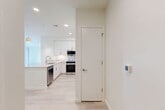 Located at 46 Soldiers Field Pl in Boston, MA, this thoughtfully designed residence offers three bedrooms, two bathrooms, and a single-floor layout that maximizes functionality and comfort. Light-toned luxury vinyl plank flooring flows throughout the entire unit, creating a cohesive and airy atmosphere.

The modern kitchen is a standout feature, showcasing white shaker cabinetry extending to the ceiling, a quartz waterfall island with an undermount sink, stainless steel appliances including a built-in microwave, electric range, and refrigerator, all illuminated by pendant lighting and recessed ceiling fixtures. The open layout connects seamlessly to the living area.

The primary bedroom is generously proportioned and benefits from large sliding glass doors that open to a private balcony with views of the surrounding Boston neighborhood. Additional bedrooms are bright and well-sized, each featuring large windows with urban and greenery views and ample closet space. Four closets total provide excellent storage throughout the unit.

The bathroom features subway tile in the walk-in shower with a glass door enclosure, large-format floor tiles, a floating white vanity, and a polished chrome fixture. An in-unit laundry area adds convenience. Clean white walls, recessed lighting, and a neutral palette give the entire residence a fresh, contemporary feel.