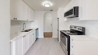 Located at 787 Vaughan Rd, Unit 302 in Toronto's vibrant Cedarvale neighbourhood, this two-bedroom, one-bathroom unit offers a well-designed layout across a single floor. A welcoming hallway introduces the space, leading to the various rooms through characterful arched doorways that lend a timeless architectural charm.

The living room is generously proportioned, featuring warm parquet wood flooring in a classic herringbone pattern and a large window fitted with a radiator beneath, allowing natural light to fill the room. The separate dining room also benefits from natural light and tile flooring, providing a dedicated space for meals.

The kitchen is thoughtfully laid out in a galley style, offering ample white cabinetry, stainless steel appliances including a range, microwave, dishwasher, and refrigerator, along with light wood-toned flooring. An arched entryway at the end of the kitchen adds an elegant touch.

Both bedrooms continue the warm parquet flooring theme, with soft grey walls and clean white baseboards creating a calm and neutral atmosphere. The primary bedroom is comfortably sized and includes a radiator and window for natural ventilation and light.

The bathroom is finished with bright white subway tile surrounding a full soaker tub and shower, complemented by a clean white vanity. Throughout, the unit maintains a fresh, bright aesthetic with consistent neutral tones.