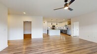 This well-appointed 3-bedroom, 2-bathroom home in Saginaw, TX offers a thoughtfully designed single-floor layout with generous living space throughout. The open-concept living, dining, and kitchen area serves as the heart of the home, featuring light wood-style flooring, recessed lighting, and a sleek ceiling fan that anchors the space. The kitchen is a standout, boasting two-tone cabinetry — white uppers paired with gray lowers — a tiled backsplash, stainless steel appliances, and a large center island with a clean white countertop illuminated by striking black pendant lights. A pantry provides additional storage convenience. The living area flows naturally toward a balcony through sliding glass doors, filling the space with natural light. Each bedroom is finished with the same warm wood-style flooring, ceiling fans, and ample closet space, including double-door closets. The primary bathroom features a dual-sink vanity with gray cabinetry, white countertops, a large framed mirror, matte black fixtures, and a soaking tub. A dedicated laundry room adds everyday practicality. Clean white walls and consistent finishes throughout give the home a bright, modern, and cohesive feel.