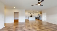 This well-appointed 3-bedroom, 2-bathroom home in Saginaw, TX offers a thoughtfully designed single-floor layout with generous living space throughout. The open-concept living, dining, and kitchen area serves as the heart of the home, featuring light wood-style flooring, recessed lighting, and a sleek ceiling fan that anchors the space. The kitchen is a standout, boasting two-tone cabinetry — white uppers paired with gray lowers — a tiled backsplash, stainless steel appliances, and a large center island with a clean white countertop illuminated by striking black pendant lights. A pantry provides additional storage convenience. The living area flows naturally toward a balcony through sliding glass doors, filling the space with natural light. Each bedroom is finished with the same warm wood-style flooring, ceiling fans, and ample closet space, including double-door closets. The primary bathroom features a dual-sink vanity with gray cabinetry, white countertops, a large framed mirror, matte black fixtures, and a soaking tub. A dedicated laundry room adds everyday practicality. Clean white walls and consistent finishes throughout give the home a bright, modern, and cohesive feel.