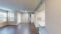This efficiently designed one-bedroom apartment offers 560 square feet of contemporary living space. The layout maximizes functionality with a 140 square foot primary bedroom, a full bathroom, and an open-concept living area that combines the kitchen and living room. The living room is a highlight, featuring a sleek fireplace and wood-look flooring that extends throughout the main living spaces. Large windows and a sliding glass door in the bedroom provide ample natural light. The kitchen boasts modern appliances, including a built-in microwave and stainless steel refrigerator, complemented by white countertops and subway tile backsplash. The bathroom is well-appointed with a vanity featuring ample storage and a shower/tub combination. Additional amenities include a closet for storage and carpet in the bedroom for added comfort. The neutral color palette and clean lines create a versatile canvas for various decor styles, making this apartment an ideal space for comfortable, low-maintenance living.