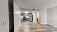 Located at 5425 Sepulveda Blvd in Los Angeles, CA, this single-floor unit offers a clean, modern interior with a thoughtfully designed open layout. Light wood-look flooring runs throughout the living areas, creating a cohesive and contemporary feel underfoot. The textured ceilings and crisp white walls provide a neutral backdrop that complements the overall design.

The kitchen is a functional highlight, outfitted with gray cabinetry, light stone-finish countertops, and a full suite of stainless steel appliances including a gas range, dishwasher, and refrigerator. An under-cabinet range hood and flush-mount ceiling light add practical detail to the space.

The open living area flows directly from the kitchen, offering generous floor space and natural light through a large window fitted with vertical blinds. A sliding panel closet provides convenient built-in storage within the main living zone.

The bathroom features dark cabinetry with a wide vanity, light countertop, and a large wall mirror with overhead lighting, offering a clean and organized feel. A hallway connects the bathroom to the rest of the unit, maintaining a practical and efficient floor plan throughout.

The unit is well-served by central HVAC with multiple vents, ensuring comfortable climate control year-round. Overall, the space presents a move-in-ready interior suited for comfortable urban living in the heart of Los Angeles.