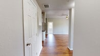 Located in Temple Terrace, FL, this well-appointed 2-bedroom, 2-bathroom single-story home offers a thoughtfully designed layout with warm hardwood flooring flowing throughout the main living areas. The open kitchen features white shaker-style cabinetry, dark stone countertops, stainless steel appliances including a dishwasher and range, and a double sink — all set against rich hardwood floors for a clean, modern aesthetic. The living room is bright and airy, showcasing vaulted ceilings, a ceiling fan, and sliding glass doors that open to a private balcony with lush outdoor views. The spacious primary bedroom features plush carpeting, a ceiling fan, and access to two closets, including a generous walk-in closet with built-in wire shelving. The second bedroom offers hardwood floors, large windows with abundant natural light, and a ceiling fan. Both bathrooms are finished with white vanity cabinetry, stone-look countertops, and tiled tub-shower combinations. Additional highlights include a dedicated utility room, hallway, and two full closets. The neutral color palette and consistent finishes throughout give the home a cohesive, move-in ready feel.