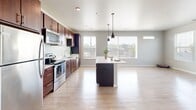 Located at 2141 S Robinson Ave in Milwaukee, WI, this well-appointed single-floor residence offers three bedrooms, two bathrooms, and a thoughtfully designed open-concept layout. The kitchen and living area form the heart of the home, showcasing rich dark-wood cabinetry, stainless steel appliances, light quartz countertops, and a central island with pendant lighting overhead. Light hardwood-style flooring flows throughout the main living area, complemented by large windows that fill the space with natural light and provide views of the surrounding greenery. The generous living area offers a bright, airy atmosphere ideal for everyday living. The three bedrooms are finished with plush carpeting, neutral gray walls, and well-sized windows that bring in ample daylight. The spacious primary bedroom provides a comfortable retreat, while the additional bedrooms offer versatility for guests or a home office. A dedicated closet adds convenient storage. The two bathrooms are finished in a clean, modern style — one featuring a tub-shower combination and the other a vanity with a dark wood base, white countertop, and large mirror. Tile flooring and contemporary fixtures complete both bathrooms. The overall aesthetic is cohesive, modern, and move-in ready.