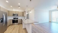 Located at 3875 W Dobbins Rd in Laveen, AZ, this 930-square-foot single-story apartment features 2 bedrooms, 2 bathrooms, and a well-designed open layout. The combined kitchen and living room serves as the heart of the home, where light wood-style plank flooring, crisp white walls, and a ceiling fan create a bright, airy atmosphere. Sliding glass doors open to an outdoor view, allowing natural light to fill the living area. The kitchen is outfitted with stainless steel appliances including a range, microwave, refrigerator, and dishwasher, complemented by light wood cabinetry, granite countertops, a tile backsplash, and a breakfast bar peninsula. Both bedrooms feature plush carpeting, ceiling fans, and dedicated closets with built-in shelving and hanging rods. The primary bedroom measures 200 square feet and connects to a well-appointed en-suite bathroom featuring dual granite-topped sinks, wood-toned cabinetry, a glass-enclosed shower, and wood-style flooring. The second bathroom mirrors the same modern aesthetic with a vanity, granite countertop, and wood-style flooring. In-unit laundry is also present, adding everyday convenience to this thoughtfully finished Laveen residence.